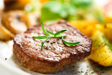 Grilled steak, baked potatoes and vegetables