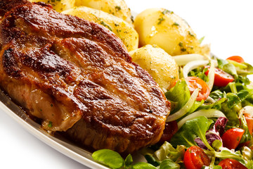 Grilled steak, boiled potatoes and vegetable salad