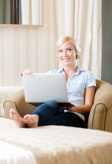 Woman sitting on the sofa with silver laptop