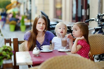 Mother and her daughters relaxing in outdoor cafe