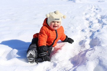 Fototapeta na wymiar 18 months baby sitting on snow