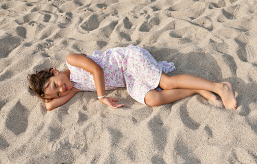 portrait of a little girl lying on the beach © alexandre zveiger