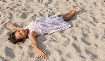 portrait of a little girl lying on the beach © alexandre zveiger