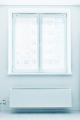 White plastic double door window with radiator under it.