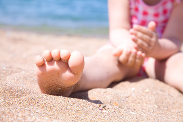 child's foot is close to the beach