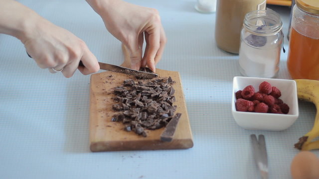Closeup video of  woman's hands cutting chocolate for a cake