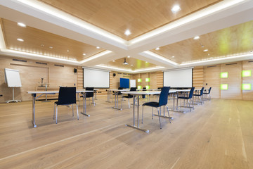 flipchart and projection screens in wooden conference room
