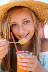 Beautiful girl with an iced drink, straw hat on beach