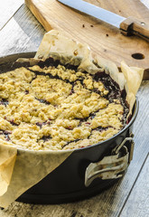 Crumble pie with black currants on baking paper