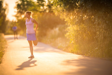 Young woman running outdoors on a lovely sunny summer evening