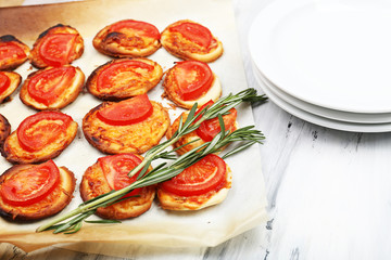 Small pizzas on baking paper close up