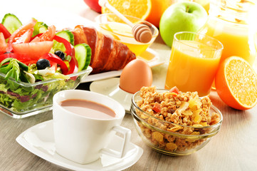 Breakfast with coffee, juice, croissant, salad, muesli and egg