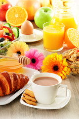 Breakfast with coffee, juice, croissant, salad, muesli and egg