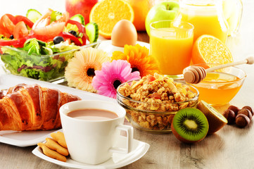 Breakfast with coffee, juice, croissant, salad, muesli and egg