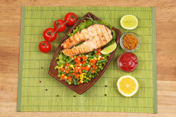 Tasty grilled salmon with vegetables, on bamboo mat