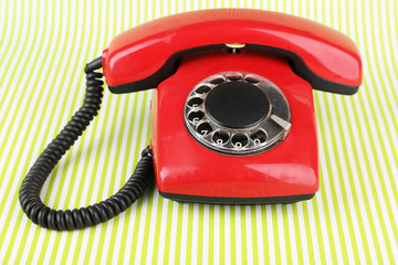 Red retro telephone on bright background