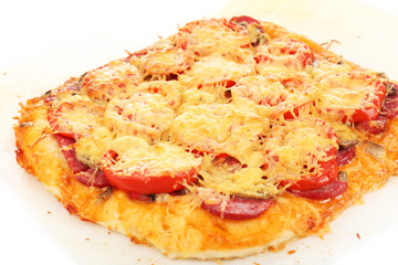 Homemade pizza on baking paper close up