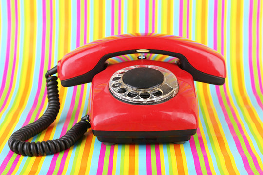 Red retro telephone on bright background