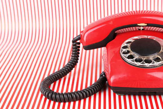 Red retro telephone on bright background