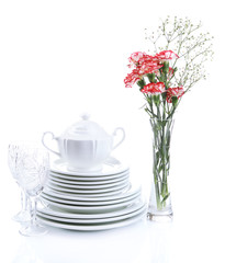Stack of white ceramic dishes and flowers, isolated on white