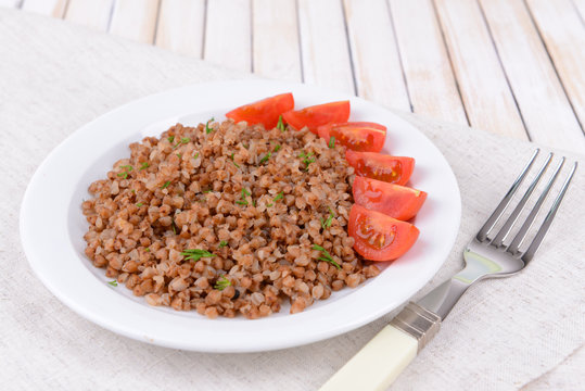 Boiled buckwheat on plate on table close-up