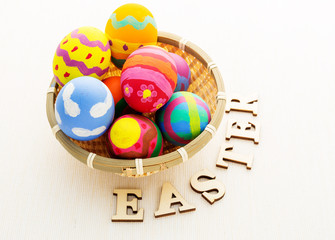 Easter egg in basket and wooden text