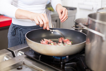 Chef or braising meat in a frying pan