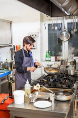 Fototapeta na wymiar Chef cooking a vegetables stir fry over a hob
