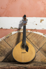 traditional portuguese guitar on a stone bench.