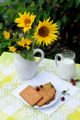 Still life with jug of milk,cookies and a bouquet