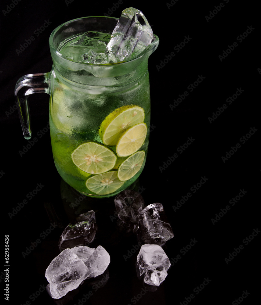 Wall mural Lime juice over black background