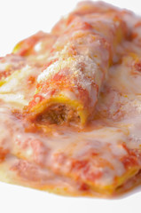 Italian cannelloni pasta with meat, tomato sauce, cheese and bas
