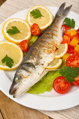 Delicious grilled fish on plate on table close-up