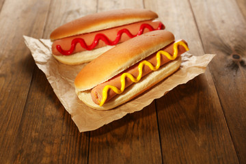 Tasty hot dogs on wooden table