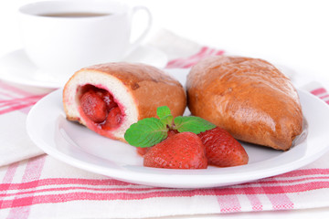 Fresh baked pasties with strawberries on plate on table