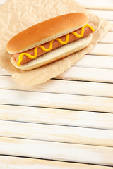 Tasty hot dog on wooden table