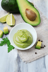 Fresh guacamole in bowl on wooden table