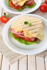 Tasty sandwich with ham on wooden table