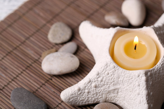Composition with spa stones, candles on bamboo mat background