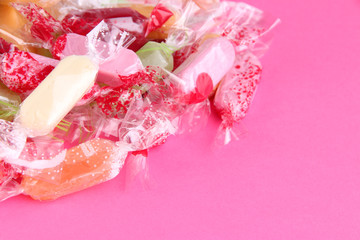 Tasty candies on pink background