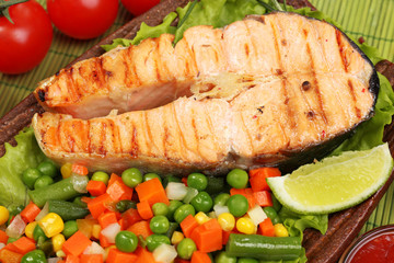 Tasty grilled salmon with vegetables, close up