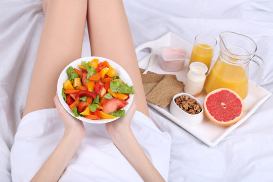 Woman in bed with light breakfast