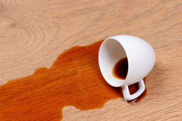 Overturned cup of coffee on floor close-up