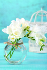 Beautiful freesia flowers, on blue wooden background