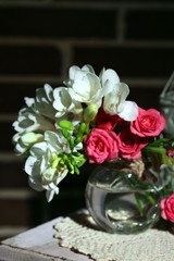 Beautiful still life with small pink roses and freesia flowers