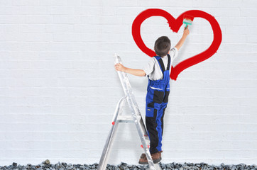 Kind malt ein Herz an die Mauer