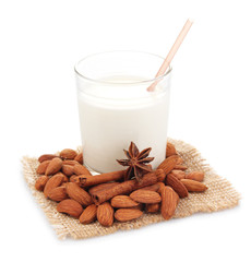 Almond milk in glass with almonds, isolated on white