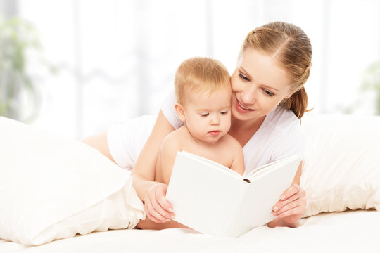 Mother Reading  Book Baby In Bed Before Going To Sleep