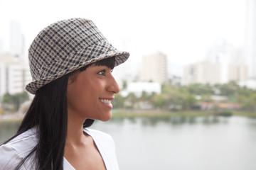 Laughing brazilian woman with hat looking sideways