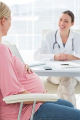 Pregnant woman consulting female doctor